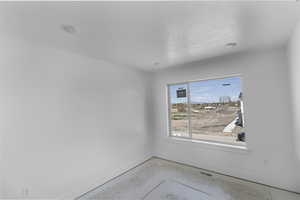 Spare room with concrete floors, visible vents, and baseboards