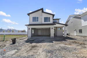 View of front of home with cooling unit, dirt driveway, a mountain view, an attached garage, and fence
