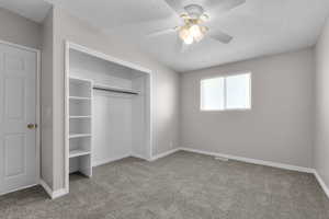 Unfurnished bedroom with a textured ceiling, a closet, baseboards, and carpet floors