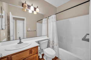 Bathroom featuring vanity, toilet, and shower / bath combination with curtain