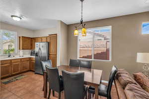 Dining space featuring light tile patterned floors, visible vents, and a textured ceiling