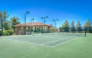 View of tennis court featuring fence and community basketball court