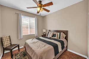 Bedroom with baseboards, visible vents, and a ceiling fan