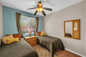 Bedroom with light tile patterned floors, ceiling fan, visible vents, and baseboards