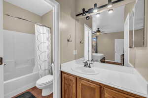 Full bath with ceiling fan, shower / tub combo with curtain, toilet, tile patterned floors, and vanity