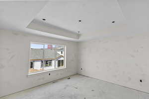 Unfurnished room with a raised ceiling and baseboards
