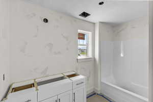 Full bathroom featuring shower / tub combination and baseboards