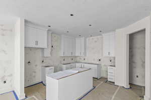 Clothes washing area featuring baseboards