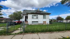 View of home's exterior with a garage, a fenced front yard, a gate, a lawn, and brick siding