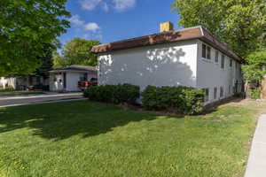 View of property exterior with a lawn and a chimney