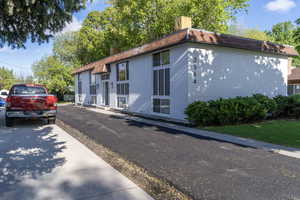 View of home's exterior featuring a chimney and brick siding