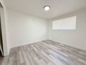 Spare room with baseboards, visible vents, and light wood-style flooring