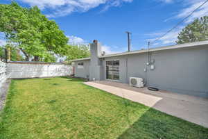 Rear view of property featuring a chimney, fence, stucco siding, and ac unit
