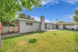 Rear view of property with a patio area, a yard, stucco siding, and fence