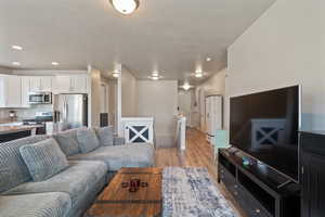 Living area with light wood finished floors and a textured ceiling