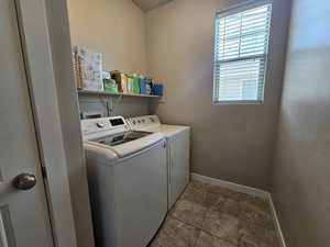Laundry area with laundry area, washing machine and dryer, and baseboards