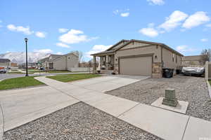Craftsman-style home with a residential view, an attached garage, a front lawn, stone siding, and driveway
