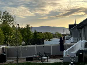 View of yard featuring a fenced backyard, a deck with mountain view, and stairway