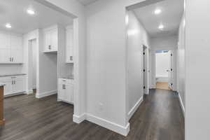 Corridor featuring visible vents, dark wood finished floors, and baseboards