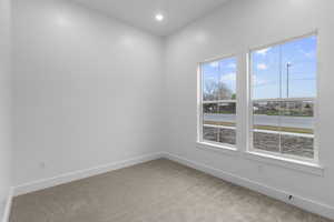 Carpeted empty room featuring recessed lighting and baseboards