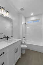 Full bath featuring tile patterned flooring, toilet, shower / tub combination, vanity, and visible vents