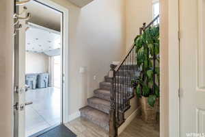 Stairs with wood finished floors and baseboards