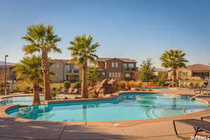Pool featuring fence, a patio area, a residential view, and a hot tub