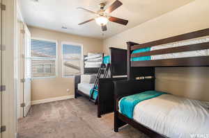 Bedroom featuring visible vents, ceiling fan, baseboards, and light carpet