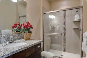 Full bath with a shower stall, toilet, and vanity