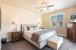 Bedroom with baseboards, visible vents, ceiling fan, and carpet floors