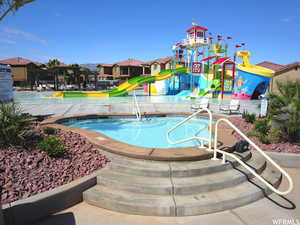 Community pool with a water slide and a water play area