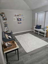 Living area featuring a textured ceiling, baseboards, and dark wood-type flooring