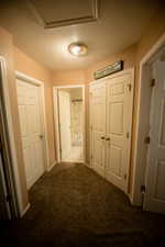 Hallway featuring carpet floors, a textured ceiling, and baseboards