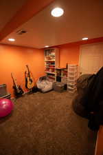 Interior space featuring carpet flooring, recessed lighting, and visible vents
