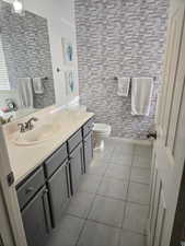 Bathroom with toilet, tile patterned flooring, and vanity