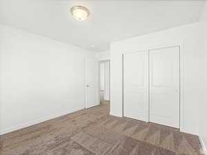 Unfurnished bedroom with a closet, carpet flooring, and baseboards