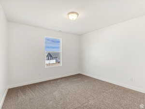 Spare room with baseboards and carpet flooring