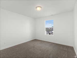 Empty room with visible vents, carpet flooring, and baseboards