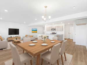 Dining area featuring recessed lighting, light wood finished floors, and a notable chandelier