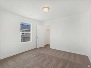 Carpeted empty room with baseboards