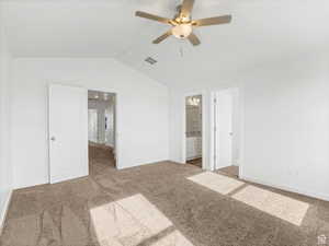 Unfurnished bedroom with lofted ceiling, visible vents, carpet flooring, and baseboards