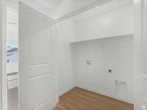 Laundry area with hookup for an electric dryer, washer hookup, baseboards, light wood-type flooring, and laundry area