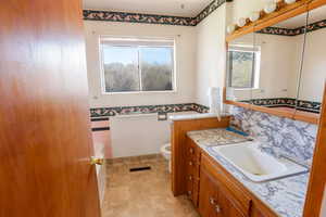 Full bathroom with visible vents, toilet, plenty of natural light, and wainscoting