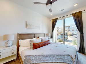 Bedroom with visible vents, access to exterior, ceiling fan, and carpet floors