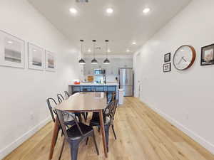 Dining room with recessed lighting, visible vents, light wood-style floors, and baseboards
