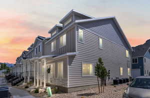 Property exterior at dusk with cooling unit and board and batten siding