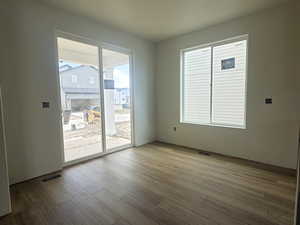 Empty room featuring visible vents and wood finished floors
