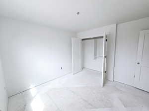 Unfurnished bedroom featuring a closet and baseboards