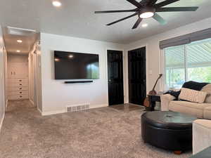 Living area with visible vents, baseboards, recessed lighting, carpet, and a ceiling fan