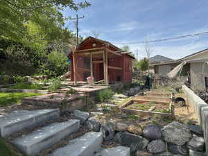 View of yard featuring an outbuilding, a garden, and fence